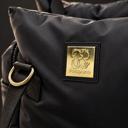 Macro close-up of the black Petsperro dog car seat: gold Petsperro nameplate on the pillow panel with a gold D-ring and strap