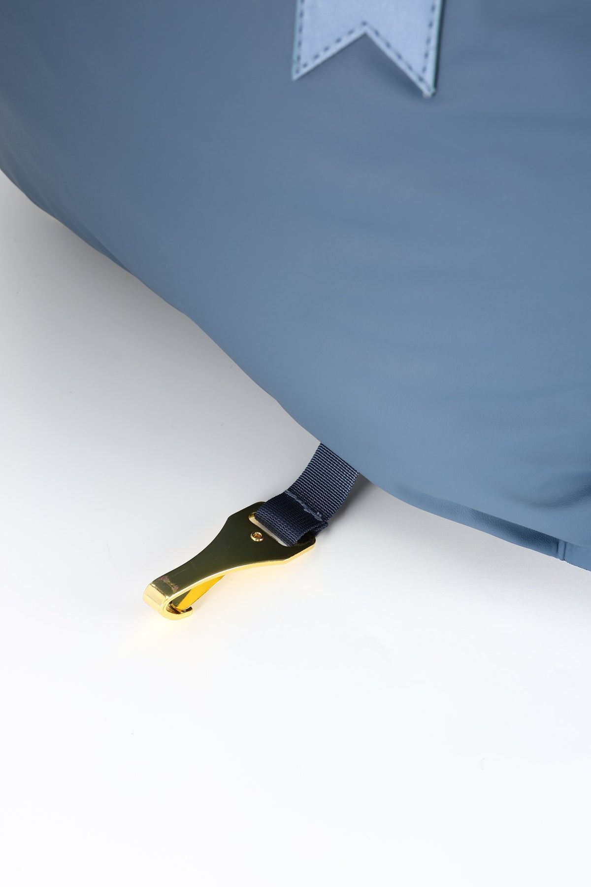 Close-up of the gold metal hook on the strap under the navy petsperro dog car seat